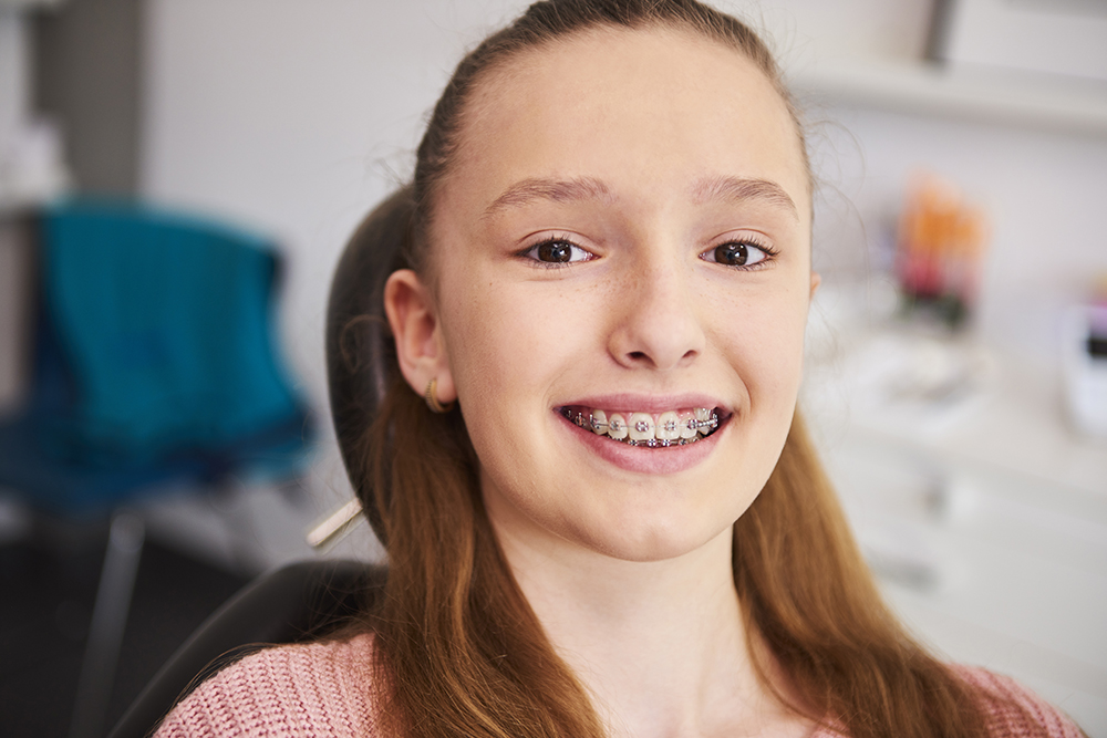 Portrait of smiling child with braces in dentist's office Ortodontia
