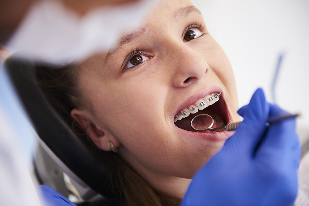 Girl with braces during a routine, dental examination Ortodontia