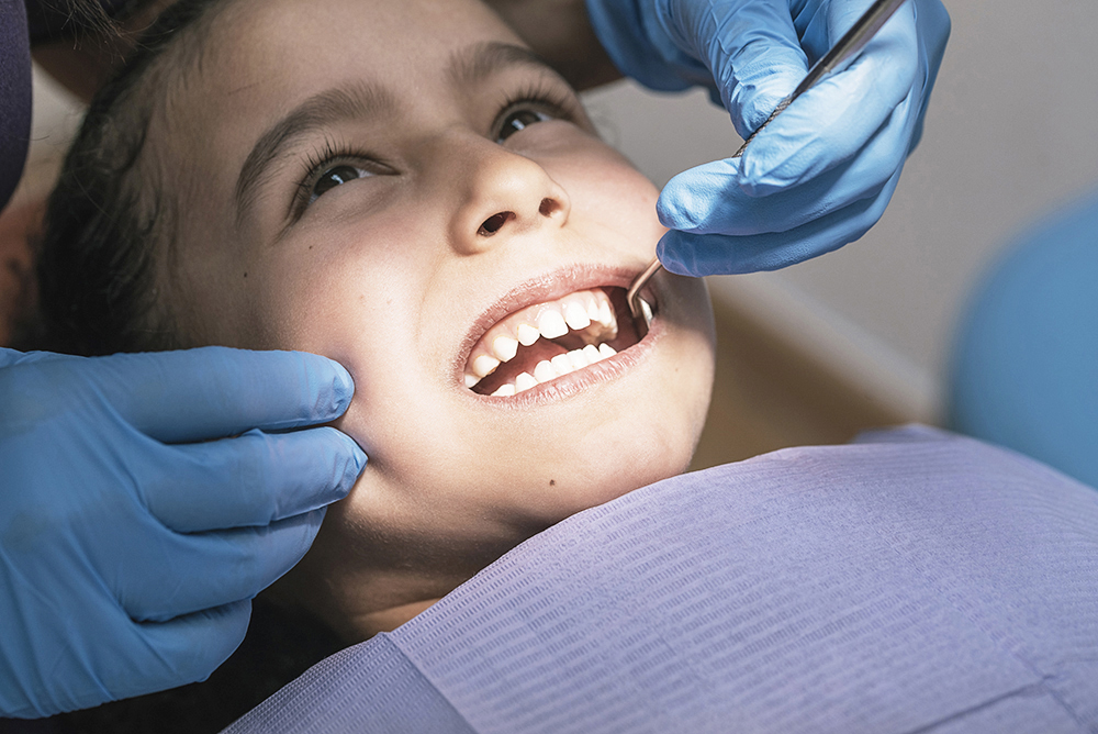 Close up of dentist during a dental intervention with a patient. Odontopediatria