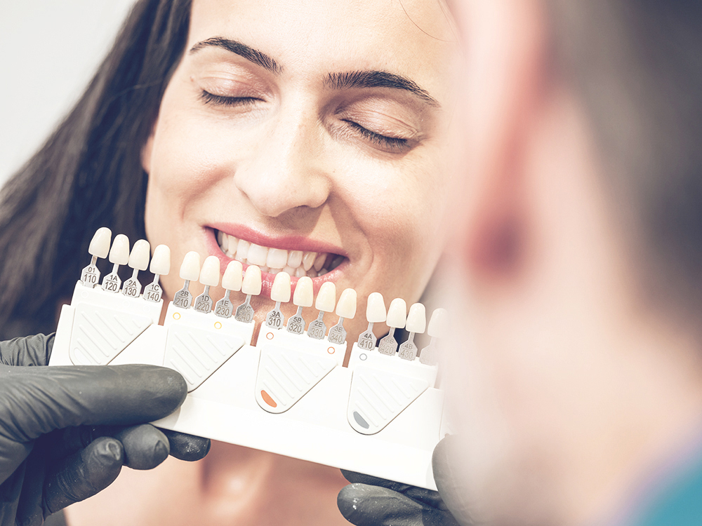 Dentist picking color of denture Prostodontia